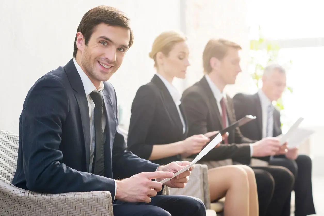 A group of people sitting in a row holding ipads.